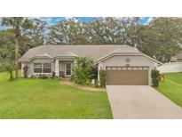 Charming single-story home with well-manicured lawn, mature trees, and welcoming front entrance, complete with a two-car garage at 4865 Gorham Ave, Orlando, FL 32817