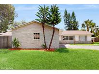 Charming single-story home with stone accents, a well-manicured lawn, and mature trees at 624 American Heritage Pkwy, Orlando, FL 32809