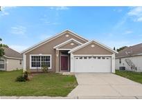 Charming single-story home with a well-maintained lawn and a two-car garage in a sunny neighborhood at 631 Lady Diana Dr, Davenport, FL 33837
