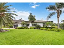Beautiful single-story home with lush green lawn, mature palm trees, and well-maintained landscaping at 7145 Lake Dr, Orlando, FL 32809