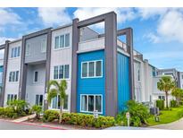 Modern townhome with striking blue and grey exterior and well-maintained landscaping at 7740 Sandy Ridge Dr # 124, Reunion, FL 34747