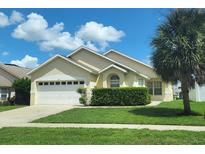 Charming single-story home with a well-manicured lawn, lush hedges, and a large palm tree providing shade at 8093 Indian Creek Blvd, Kissimmee, FL 34747