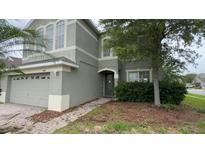 Two-story home featuring neutral paint and a welcoming front entrance with brick path and a manicured lawn at 14508 Cedar Branch Way, Orlando, FL 32824