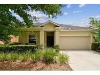 Charming one-story home featuring a two-car garage, manicured landscaping and a covered front porch at 2409 Martins Run, Tavares, FL 32778