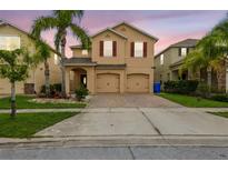 Charming two-story home featuring a well-maintained lawn, mature palm trees, and a two-car garage at 2777 Monticello Way, Kissimmee, FL 34741