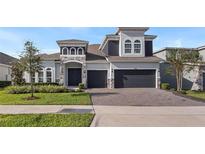 Stunning two-story home featuring a stone facade, manicured lawn, and a two-car garage at 4413 Lions Gate Ave, Clermont, FL 34711