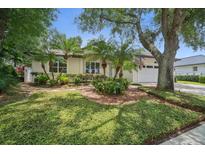 Charming home with a manicured lawn, mature trees, and palm trees at 489 Penny Ln, Maitland, FL 32751