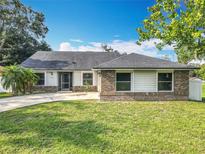 Charming single-story home boasts a brick and siding facade, mature trees, and a well-maintained lawn at 4942 Eden View Ct, Orlando, FL 32810