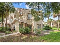 Inviting exterior view of a townhome featuring manicured landscaping and a charming entrance at 5436 E Michigan St # 7, Orlando, FL 32812