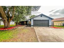 Charming single-story home features a well-maintained front yard and a two-car garage at 6849 Palomino Dr, Lakeland, FL 33811