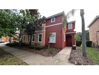 Two story townhouse with a stucco exterior and well-kept landscaping at 720 Las Fuentes Dr, Kissimmee, FL 34746
