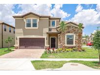 Charming two-story home features stone accents, a two-car garage, and beautifully landscaped front yard at 8801 Corcovado Dr, Kissimmee, FL 34747