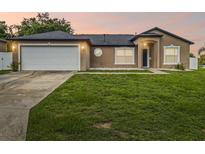 Charming single-story home with a well-maintained lawn and attached two-car garage, showcasing curb appeal at 112 Lake Butler Ave, Haines City, FL 33844