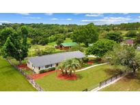 Aerial view of a well-maintained home with sprawling green property and barn at 12434 Sullivan Rd, Clermont, FL 34715