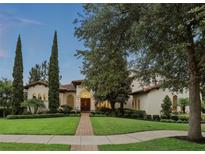Elegant home featuring manicured landscaping and a red brick walkway leading to the arched entryway at 1425 Dunbrooke Loop, Longwood, FL 32779