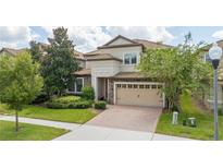 Charming two-story home features a stone facade, tile roof, and well-manicured landscaping at 1439 Moon Valley Dr, Davenport, FL 33896