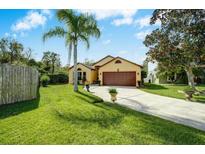 Well-maintained home featuring a lush lawn, mature trees, and a charming two-car garage at 149 Spanish Bay Dr, Sanford, FL 32771