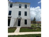 Modern townhouse showcasing a black front door and landscaping at 15095 Grove Lake Dr, Winter Garden, FL 34787