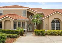 Inviting front exterior of home featuring a red tile roof, stucco facade, and lush landscaping at 1705 Saint Tropez Ct, Kissimmee, FL 34744