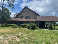 Rustic two-story home with a covered porch and a porte-cochere at 17952 Lookout Hill Rd, Winter Garden, FL 34787