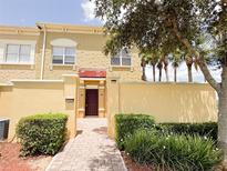 Inviting townhome exterior features a private courtyard, lush landscaping, and a warm, textured facade at 2404 Bella Vista Dr, Davenport, FL 33897