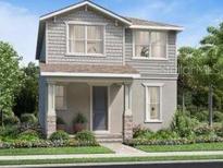 Charming two-story home featuring a covered porch, neutral color palette, manicured lawn, and lush landscaping at 2547 Long Pine Ave, Apopka, FL 32712