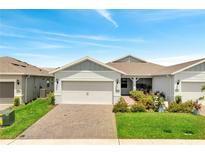 Charming single Gathering home with a lush landscaped yard, brick driveway, and an attached two-car garage at 2578 Cliff Way, St Cloud, FL 34771