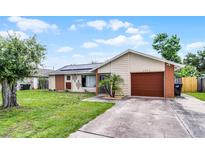Charming single-story home featuring a brick and siding exterior, solar panels, and a well-manicured lawn at 2809 Redditt Rd, Orlando, FL 32822