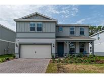 Charming two-story home featuring a two-car garage, covered porch, and inviting curb appeal at 4007 Meandering Bay Dr, Apopka, FL 32712