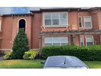 Two-story condo building with well-maintained landscaping and stucco exterior at 5116 Conroy Rd # 411, Orlando, FL 32811