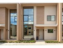 Modern townhome with large windows, neutral tones, and tasteful landscaping at 7461 Bleecker Ln, Kissimmee, FL 34747