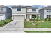 Charming two-story home with a well-manicured lawn, solar panels, a two-car garage, and a welcoming front porch at 7639 Agrigento St, Clermont, FL 34714
