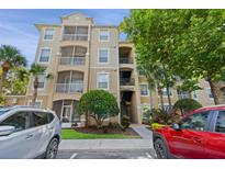 Condo building with multiple levels, screened in patios, and well manicured landscaping at 7660 Comrow St # 203, Kissimmee, FL 34747