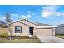Charming single-story home with a well-manicured lawn, inviting entry and two car garage at 865 Citrus Reserve Blvd, Davenport, FL 33837
