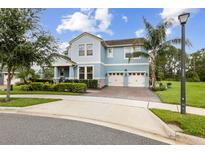 Charming two-story home features a well-manicured lawn, two-car garage, and inviting light blue color at 9844 Beach Port Dr, Winter Garden, FL 34787