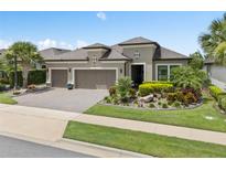 Charming home featuring a well-manicured lawn, mature landscaping, and a three-car garage at 1212 Zeek Ridge St, Clermont, FL 34715