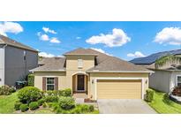 Charming single-story home with tan exterior, a two-car garage, and neatly manicured landscaping at 12216 Prairie Plantation Way, Orlando, FL 32824