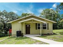 Charming single-story home featuring a cozy front porch and well-maintained lawn at 1335 E 3Rd Ave, Mount Dora, FL 32757