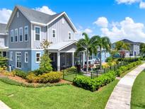Charming two-story home showcasing manicured landscaping, lush green lawns, and a welcoming outdoor living space at 14366 Walcott Ave, Orlando, FL 32827