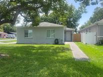 Charming single-story home features a lush green lawn and mature trees, creating a welcoming curb appeal at 1501 Delaware Ave, St Cloud, FL 34769