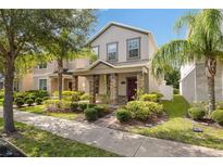 Charming two-story home featuring stone accents, a landscaped yard, and a welcoming covered front porch at 15229 Evergreen Oak Loop, Winter Garden, FL 34787