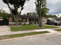 Charming single story home with a lawn, mature trees, dark shutters, and outdoor seating area on the front porch at 170 N Fairfax Ave, Winter Springs, FL 32708