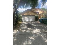 Beige single-Gathering home showing a closed two car garage door with driveway at 2155 Fennell St, Maitland, FL 32751