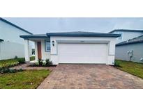 Charming single-story home featuring a two-car garage and a well-maintained brick driveway at 29783 Anahid Dr, Leesburg, FL 34748
