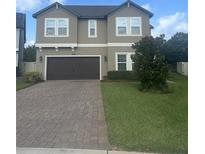 Charming two-story home with a well-maintained lawn, brick driveway, and a two-car garage at 3172 Jade Tree Pt, Oviedo, FL 32765