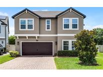 Two-story home with a brown garage door, brick driveway, and well-maintained landscaping at 3172 Jade Tree Pt, Oviedo, FL 32765