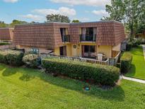A charming townhouse boasts a private balcony, fenced patio, and verdant green lawn at 5287 Cypress Ct # 724, Orlando, FL 32811