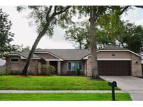 Charming single-Gathering home with brick exterior, mature trees, and a well-maintained lawn at 687 N Endeavour Dr, Winter Springs, FL 32708