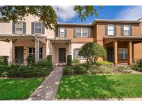 Charming townhome with a well-manicured lawn, beautiful landscaping and inviting front entrance at 9140 Grey Moss Dr, Orlando, FL 32832
