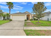 Charming single-Gathering home with well-manicured lawn and mature trees creating curb appeal at 915 Lockbreeze Dr, Davenport, FL 33897